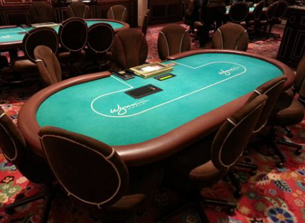 Poker table with seven players playing cards and chips.