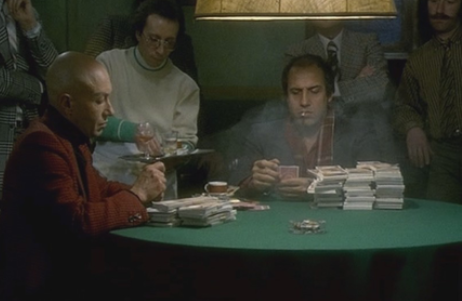 “Player named Chilintano remains calm at a poker table. His face is neutral and shows no emotion. Cards and chips are spread out on the table, with other players sitting around. The atmosphere is focused and controlled.”